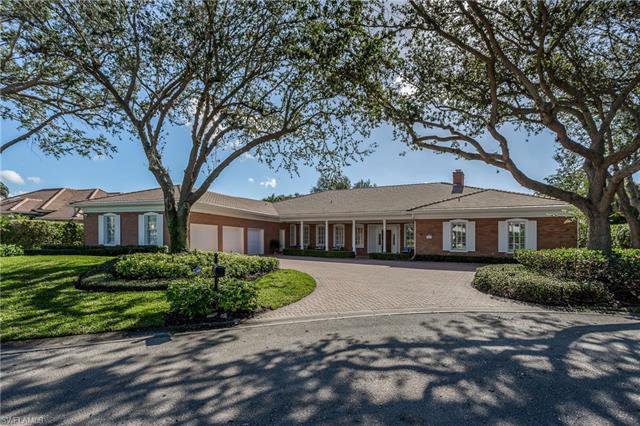 This gracious home is located on a private cul-de-sac in the coveted Pelican Bay Woods community of 