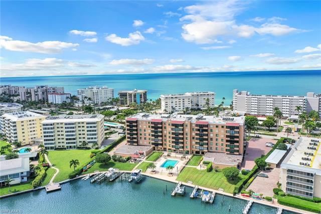 Located a mere 250 steps from the pristine Naples beach, this pristine and stunning unit is located in the exclusive Madrid Club in the Moorings and offers amazing and unequaled panoramic views of Naples Bay from every window. This 2-Bedroom, 2-Bath condominium is open, bright and filled with natural light all day long. Boasting an expansive Primary Suite with renovated Bathroom, spacious second Bedroom en-suite with renovated bathroom, formal dining area, and a spacious glass enclosed & screened lanai that encompasses the ultimate indoor/outdoor lifestyle.bedroom windows, under-building parking garage and extra storage closet...this is the one! Madrid Club recently had a multi-million dollar renovation offering an impressive Lobby, Social/Party room, Fitness Center, Catering Kitchen and an on-site, full time Property Manager. Other exclusive amenities include a massive New Pool Area, Party Pavilion with Outdoor Kitchen, Kayak Racks and Launching Dock. All located just across from the beach and a short stroll to all the amazing Restaurants and Shops located at Venetian Village! Memberships to the Moorings private residence beach are also available.