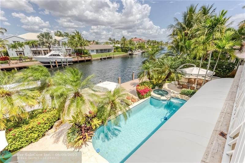Situated on a wide, deep water canal w/ direct ocean access in Lighthouse Point, this coastal contemporary home features 5Beds, 6.5bath & 3 car garage. This home has it all! Exquisite culinary kitchen, grand living/dining area with 23ft ceilings, large & open kitchen & family room overlooking the water. The main floor: Saturnia marble, 2 beds w/ ensuite baths, guest bath, laundry, formal living & dining room, family room, built in bar & an open kitchen. Upstairs hosts the 1200+/- sqft Primary Suite w/ 2 walk-in closets, dual bathrooms, coffee bar, sitting area & balcony. Two additional guest suites & a loft. Fantastic patio areas are framed by tropical landscaping, heated pool/spa, Summer kitchen & newer composite dock. Enjoy this prime wat