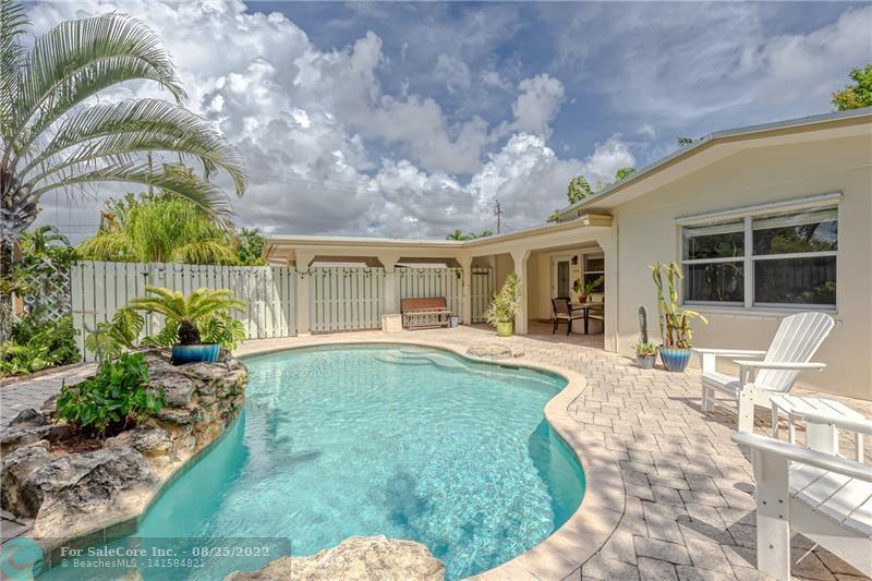 Bright and open Coral Gardens Wilton Manors home -- front pool courtyard welcomes you with a tropical resort vibe.  Large salt water pool surrounded by natural landscaping, no watering needed.  Covered patio perfect for outdoor living.  Spacious living /dining areas all on the same level, no "step downs".  Great for entertaining with living room views of the pool and French doors out to the back yard garden.  Both bathrooms updated.  3rd bedroom / office off the Kitchen - sunny and pleasant space.   Kitchen has gas stove, newer dishwasher.  Separate laundry / storage room, with newer washer & dryer, and newer hot water heater.  House protected by impact front door and hurricane shutters.  Wonderful neighborhood where everyone walks their do
