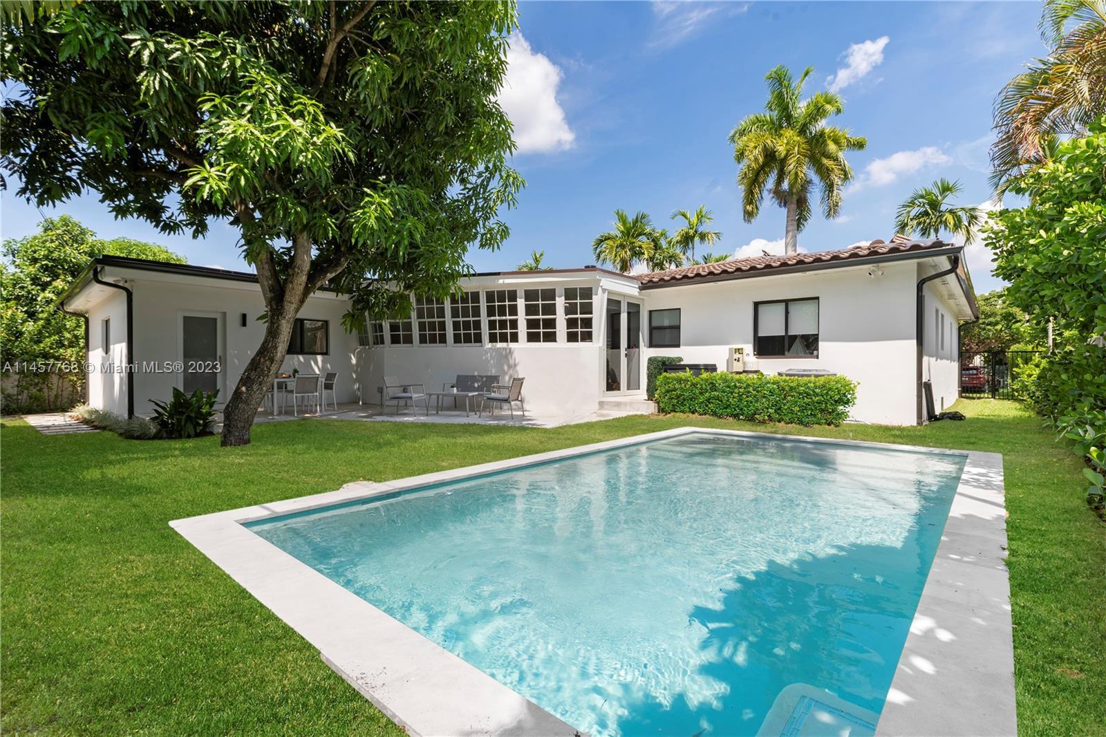 Indulge in the calming coastal ambiance of this meticulously fully renovated mid-century pool home i