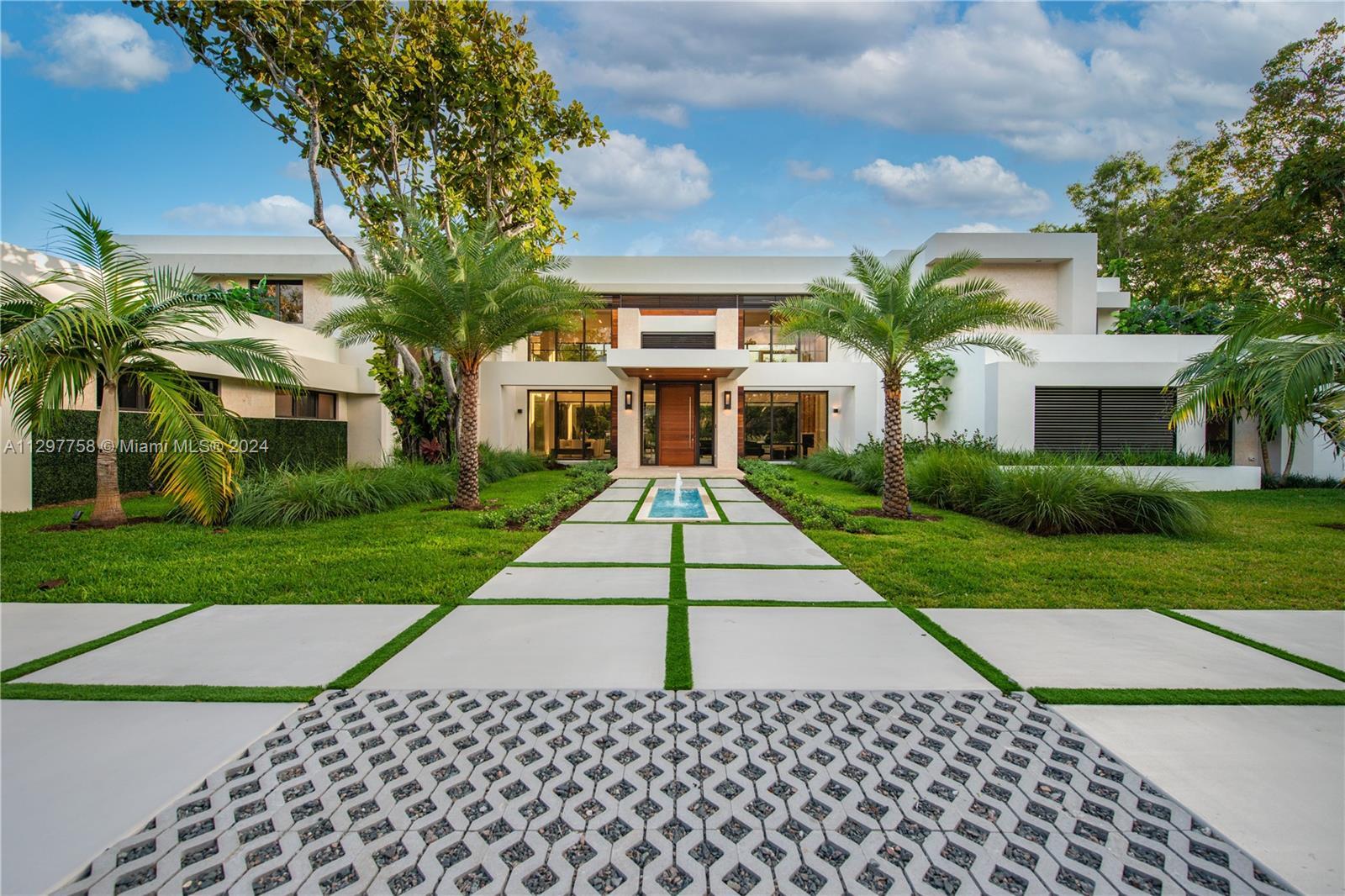 Nestled on a tranquil road in desirable North Pinecrest, this stunning modern residence sits on a sp
