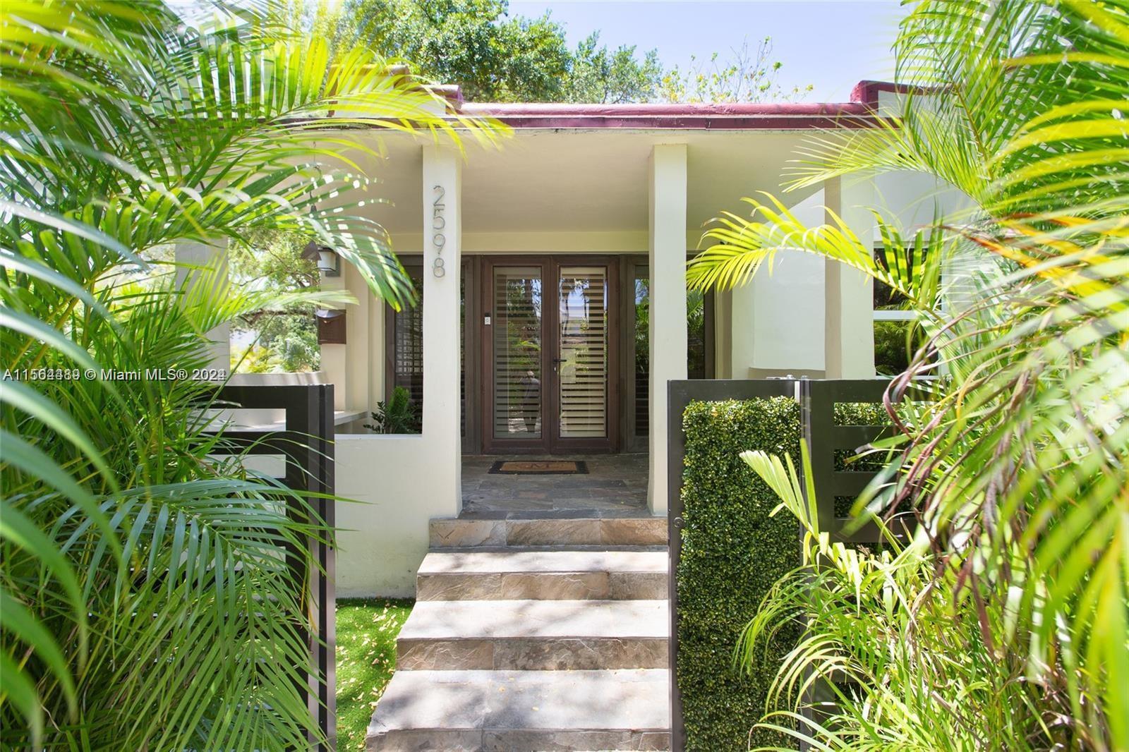 Stunning mid-century home on a tree-lined street in lush Coconut Grove. Major renovation including n