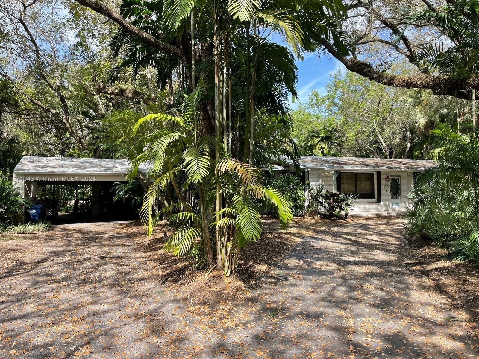 This 4-bed, 3-bath, plus den, North Pinecrest FL home sits on a one-acre lot. A lush garden, pool, a