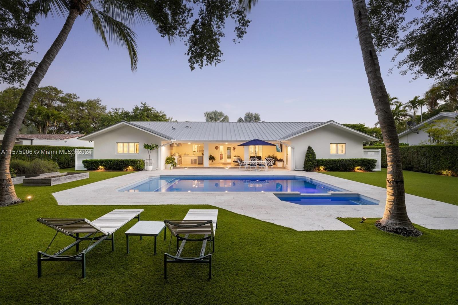 Welcome to your South Miami paradise, nestled on a spacious 14,838sf lot adorned with lush artificia