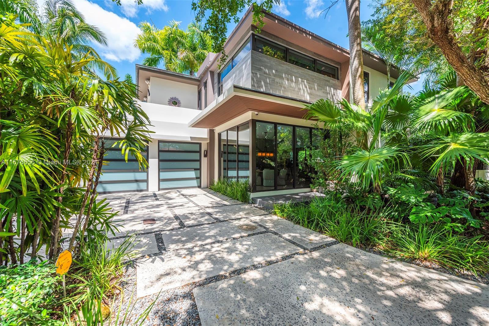 Modern Miami intersects w/Old Grove in this contemporary masterpiece framed by mature palms, oaks & 