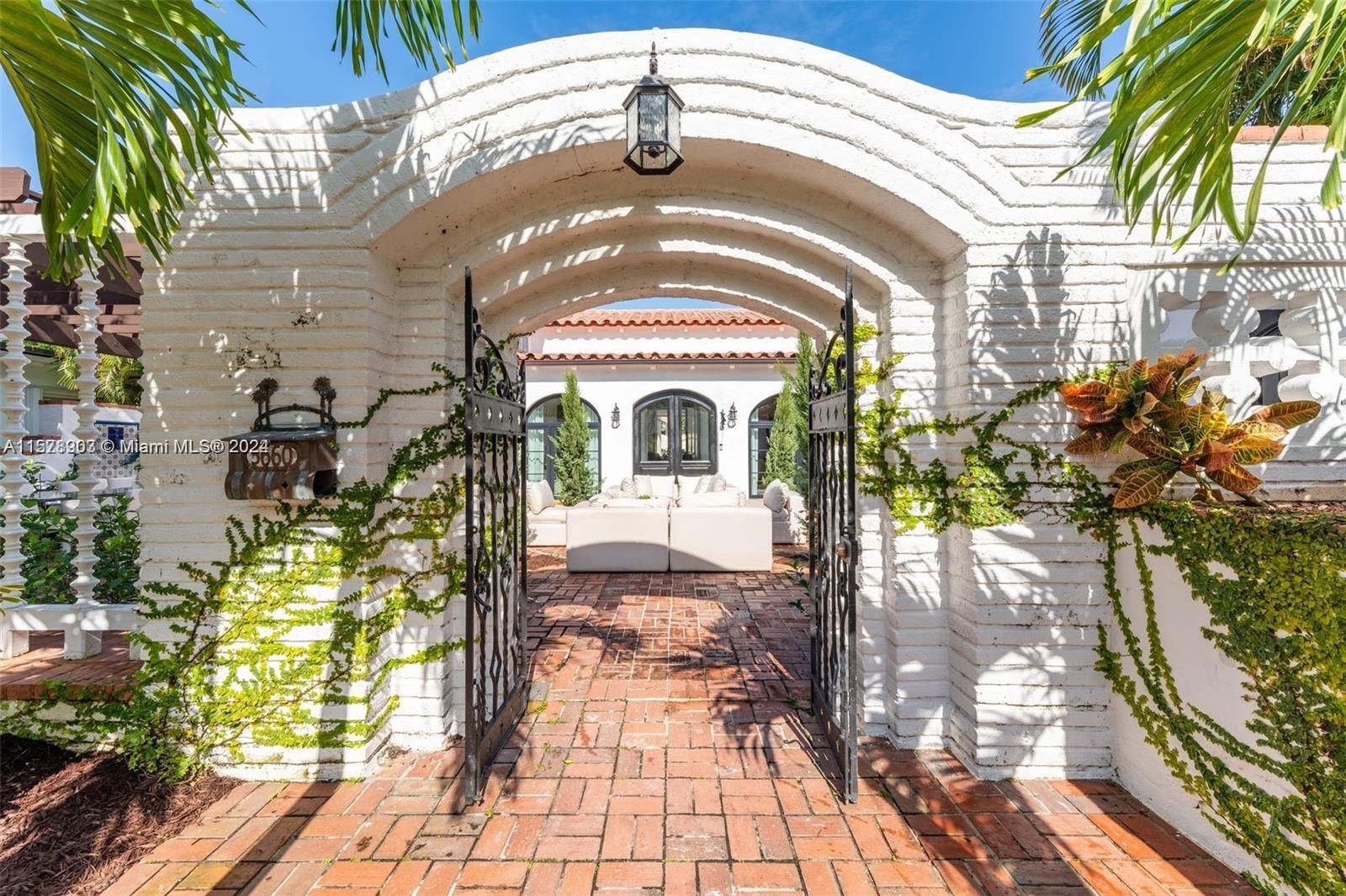 Step into this Spanish Mediterranean home with an impressive, gated courtyard featuring a water foun